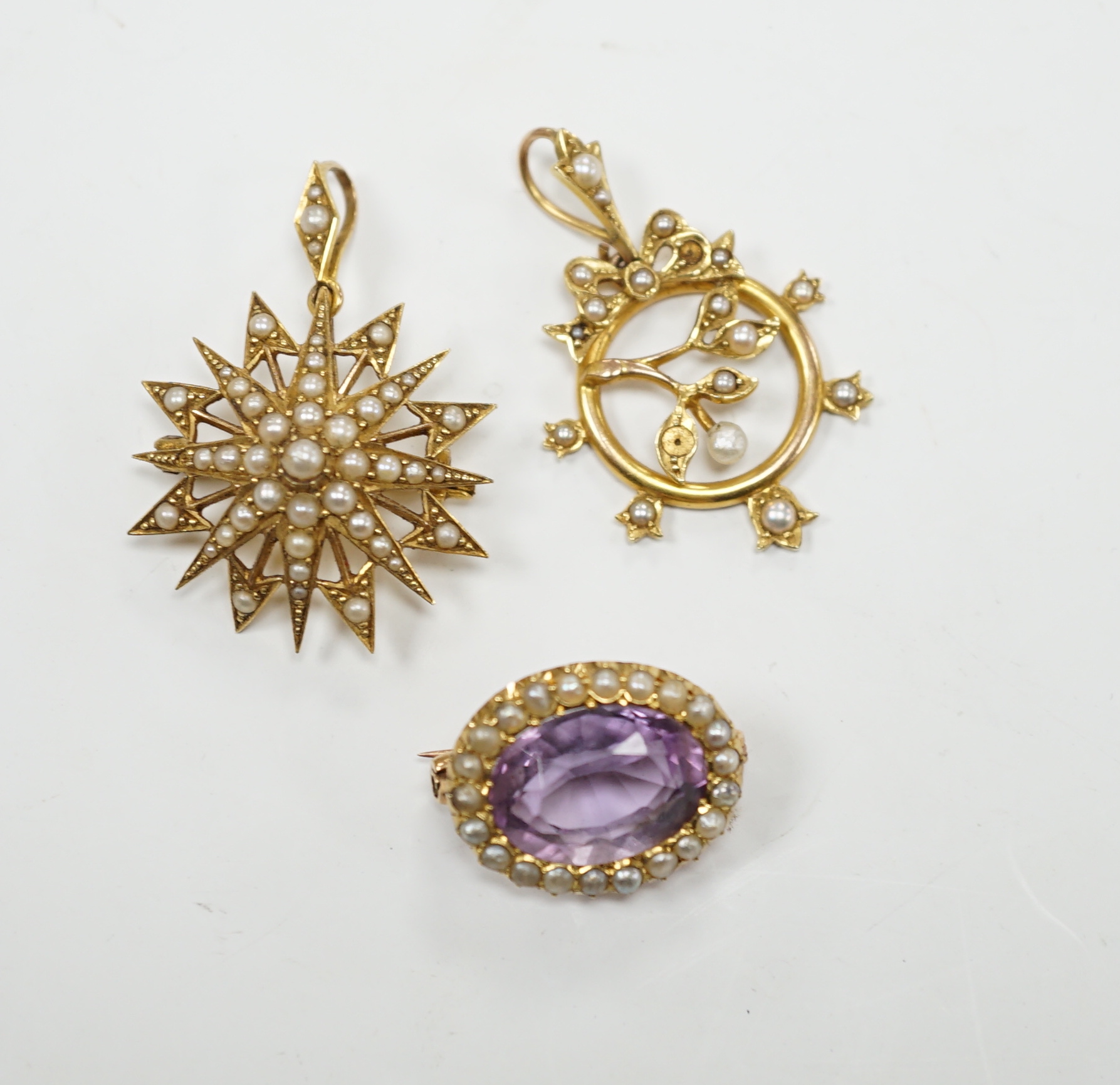 A Victorian 15ct, amethyst and seed pearl foliate pendant and a similar yellow metal and seed pearl set starburst pendant, gross weight 10.6 grams.